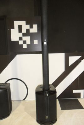 two speakers sitting next to each other on the floor