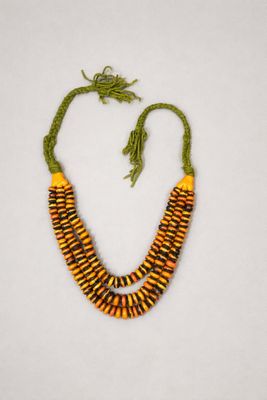 un collier composé de perles jaunes et vertes sur un fond blanc