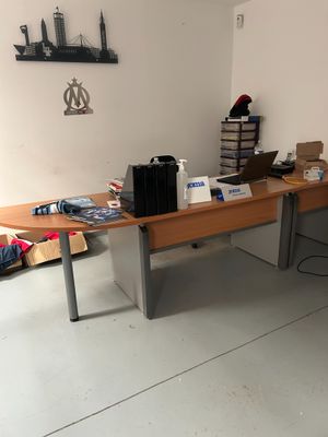 une photo d'un bureau dans une pièce où il y a beaucoup d'objets posés dessus
