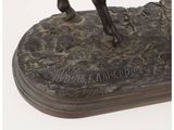 bronze statue of a man riding a horse on top of a rock