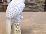 a white bird sitting on top of a tree stump