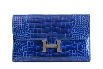 a blue leather clutch bag with a metal h on the front