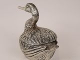 a silver bird sitting on top of a silver container
