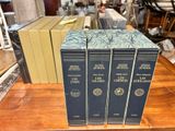 three books are sitting on a table in front of a pile of other books