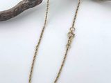 a close up of a gold chain on a branch