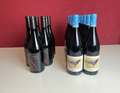 quatre bouteilles de vin rouge sont alignées sur une table