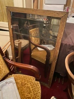 un miroir et une chaise dans une pièce recouverte d'un tapis rouge