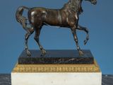 bronze statue of a horse on a marble base on a blue background