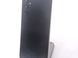 the back of a black cell phone sitting on top of a metal stand