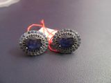 paire de boucles d'oreilles en tanzanite et saphir bleu sur un fond noir