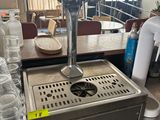 Des bouteilles d'eau sont alignées sur le comptoir d'un café.