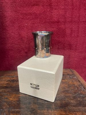a small silver cup sitting on top of a wooden box