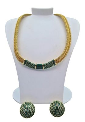 a green and gold necklace and earrings set on a mannequin