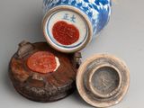 a blue and white vase with a red seal on top of it