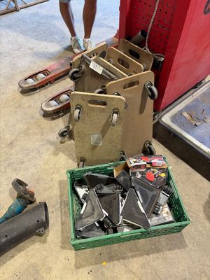 un homme debout à côté d'une pile de skateboards et d'une caisse à outils