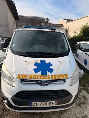 a white van parked in front of a building with an ambulance sign on it