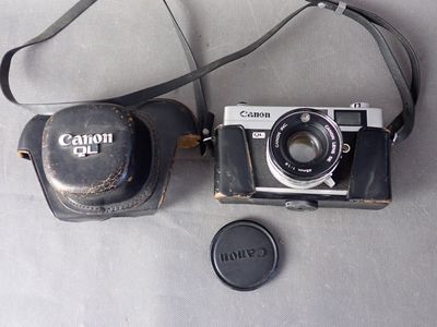 un appareil photo et un objectif posés sur une table, à côté d'un étui à appareil photo