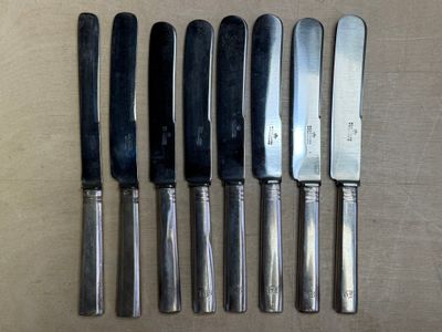six couteaux sont alignés sur une table