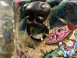 a vase with a dragon on it sitting on a table