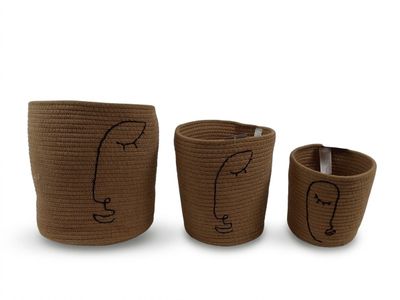 un lot de trois paniers marron sur lesquels sont dessinés des visages