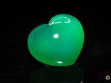 un ballon vert en forme de cœur posé sur une surface noire