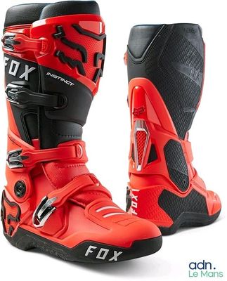 une paire de bottes de moto rouges et noires sur fond blanc