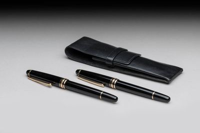 a pair of pens and a case sitting on top of a table
