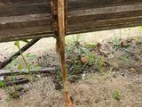 a wooden bench that has rust on it in the dirt