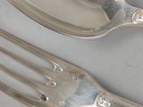 two forks and a spoon sitting on a table