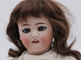 a close up of a doll wearing a white dress