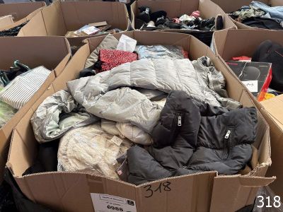 de nombreux cartons remplis de vêtements qui traînent par terre