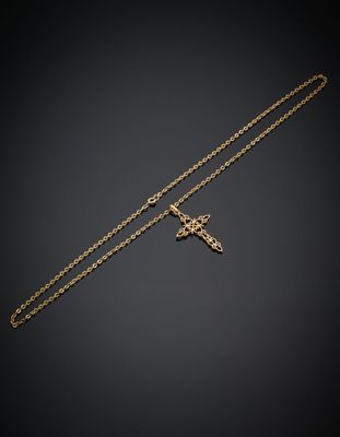 un collier en or avec une croix suspendue à une chaîne