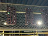 a large metal sign hanging from the ceiling of a book store