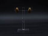 a close up of a pair of earrings on a stand