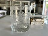un verre d'eau posé sur une table à côté d'une boîte