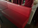 a red bench that is sitting in front of a red curtain