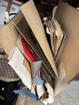 une boîte remplie de livres et de papiers posée par terre