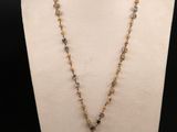 un collier auquel est suspendue une clochette en verre, sur un mannequin