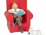 une figurine représentant un homme assis sur une chaise, avec un chien à ses côtés
