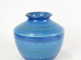 a blue vase that is sitting on a white surface