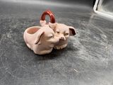 deux cochons en céramique posés sur une table