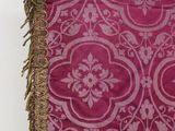 a close up of a pink and gold table runner