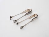 three silver spoons sitting on top of a table next to each other