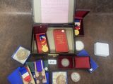 une boîte contenant des médailles, des livres et d'autres objets, posée par terre