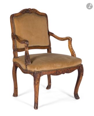 une vieille chaise en bois dont l'assise est recouverte d'un tissu beige