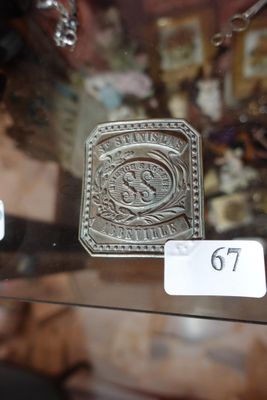 a glass display case with a silver belt buckle on it