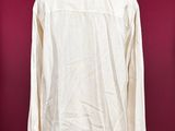 a white shirt on a mannequin stand against a red wall