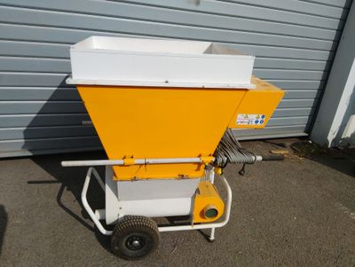 a small yellow machine that is sitting on a cart