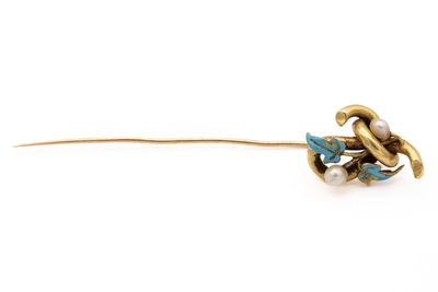 un gros plan sur une broche en forme de fleur, en or et turquoise