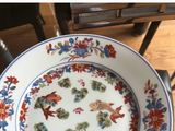 a plate with a fish design on it sitting on a chair